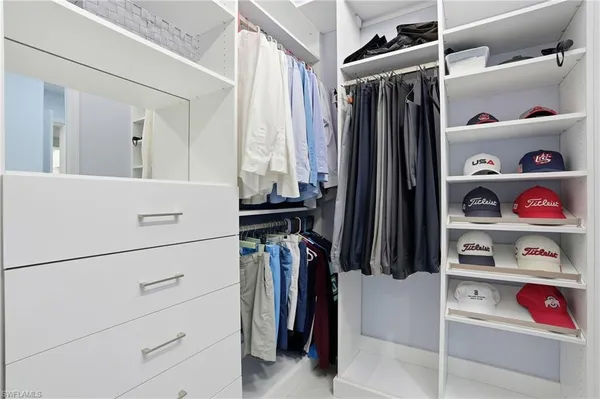 a view of walk in closet with clothes and shoes