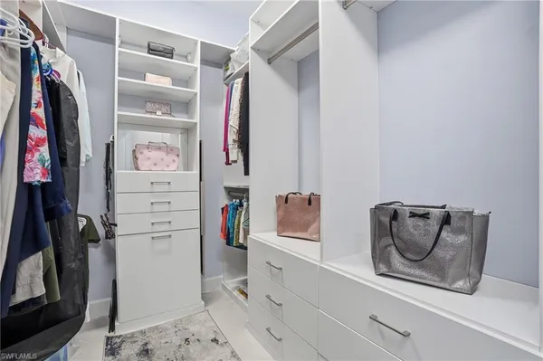 a view of walk in closet with clothes and shoes
