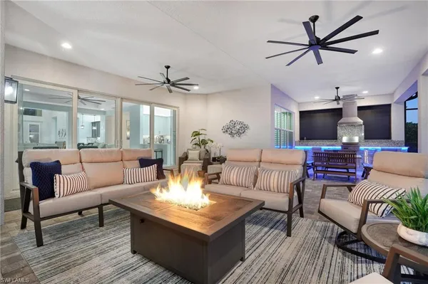 a living room with furniture kitchen view and a chandelier