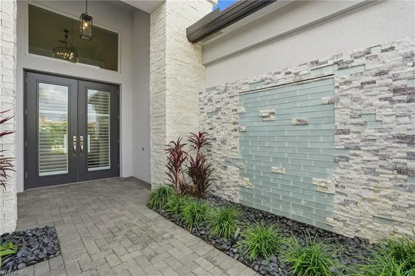 a view of a brick house with potted plants in front of door