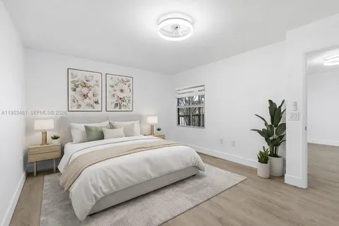 a bedroom with a large bed and a potted plant