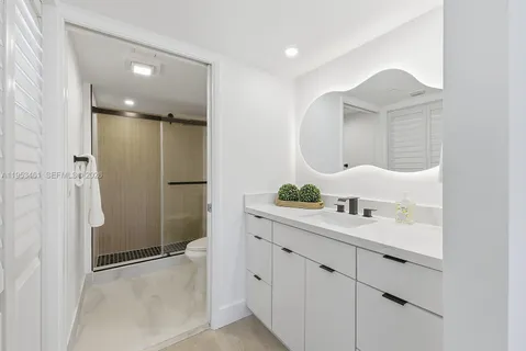 a bathroom with a double vanity sink mirror and shower