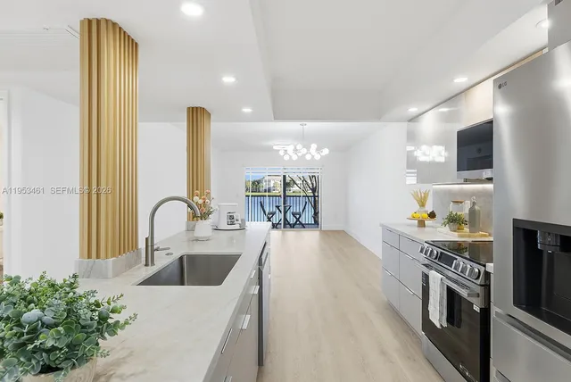 a kitchen with stainless steel appliances a sink a stove top oven a counter space and cabinets