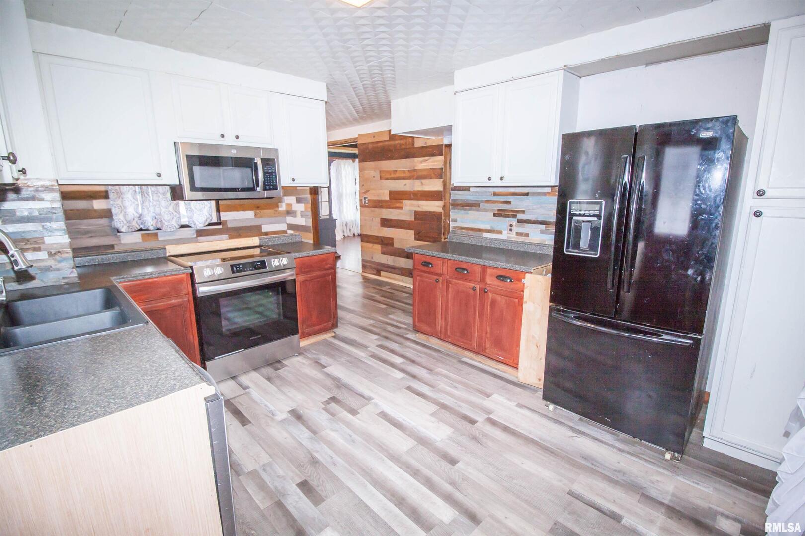 201 North 1st Street Alpha, IL 61413 - Photo 11 of 28 a kitchen with stainless steel appliances granite countertop a refrigerator stove and oven