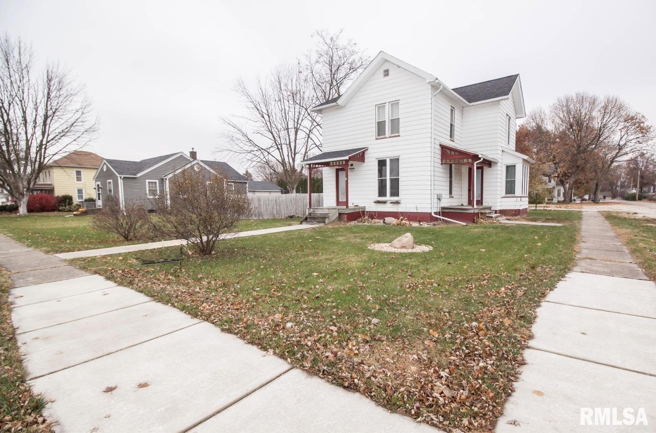 201 North 1st Street Alpha, IL 61413 - Photo 3 of 28 a view of a white house next to a yard with large trees