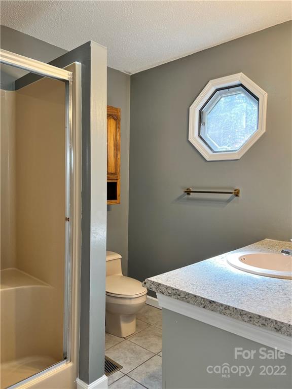 110 Joycetown Church Road Southwest Lenoir, NC 28645 - Photo 26 of 42 a bathroom with a granite countertop toilet a sink and mirror