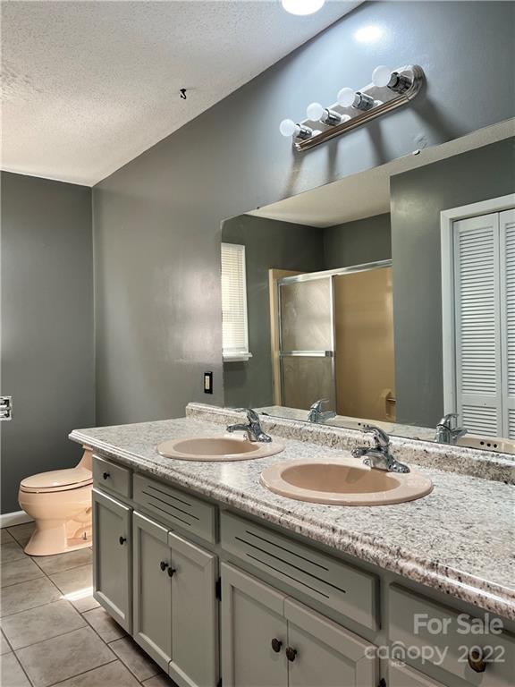 110 Joycetown Church Road Southwest Lenoir, NC 28645 - Photo 32 of 42 a bathroom with a granite countertop sink a large mirror and toilet