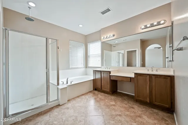 a large bathroom with a large tub shower double sink and mirror