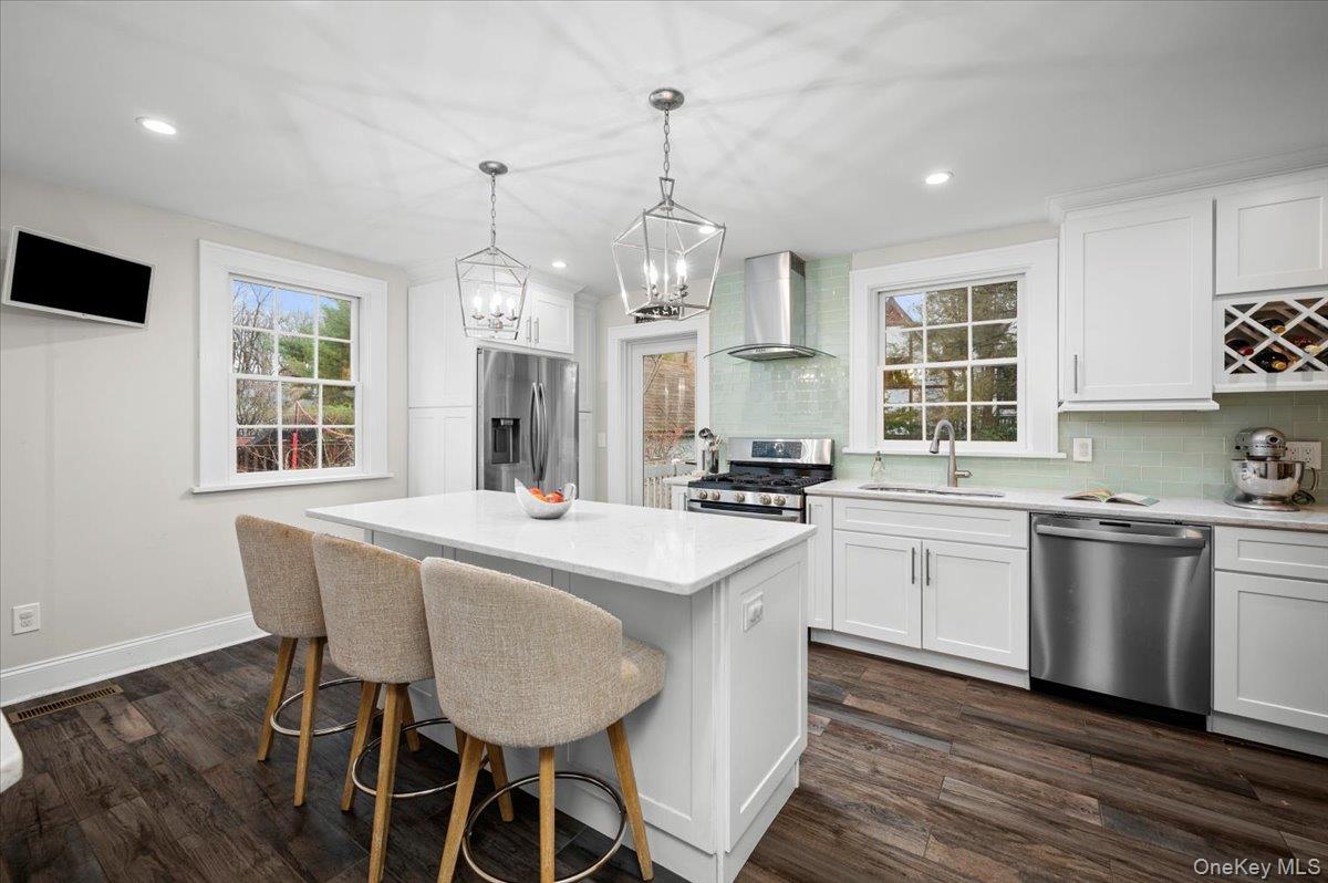 19 Nassau Road Larchmont, NY 10538 - Photo 10 of 40 a large white kitchen with granite countertop a stove a sink a dining table and chairs