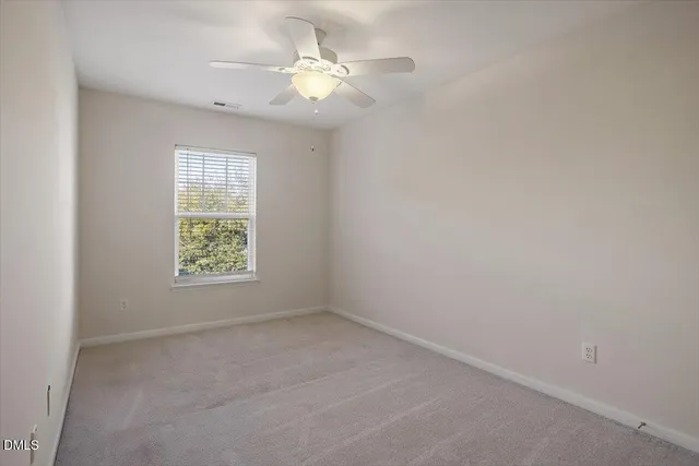 an empty room with a window and a fan