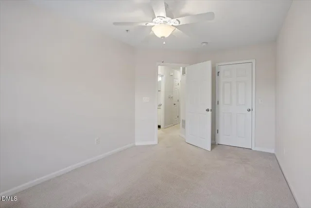 an empty room with a ceiling fan and a fan
