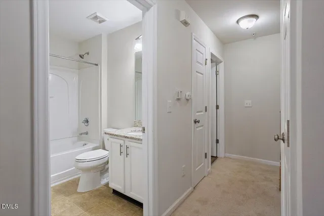 a bathroom with a granite countertop toilet a sink and a mirror