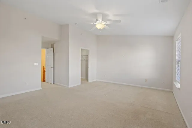 a view of an empty room with a chandelier fan