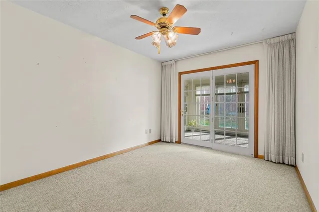 an empty room with chandelier fan