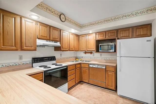 a kitchen with stainless steel appliances granite countertop a stove a sink dishwasher and a refrigerator