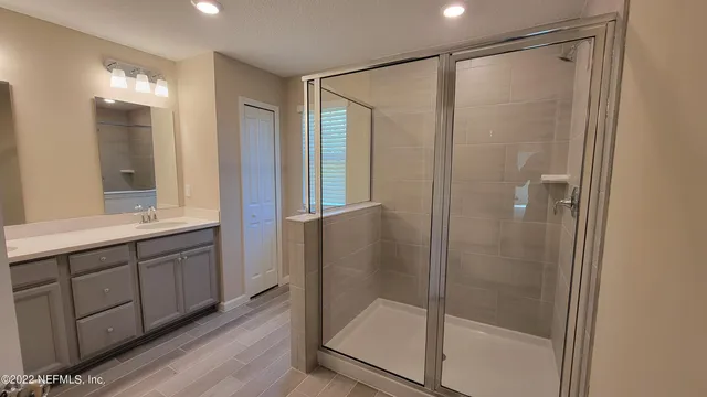 a bathroom with a shower and a sink mirror