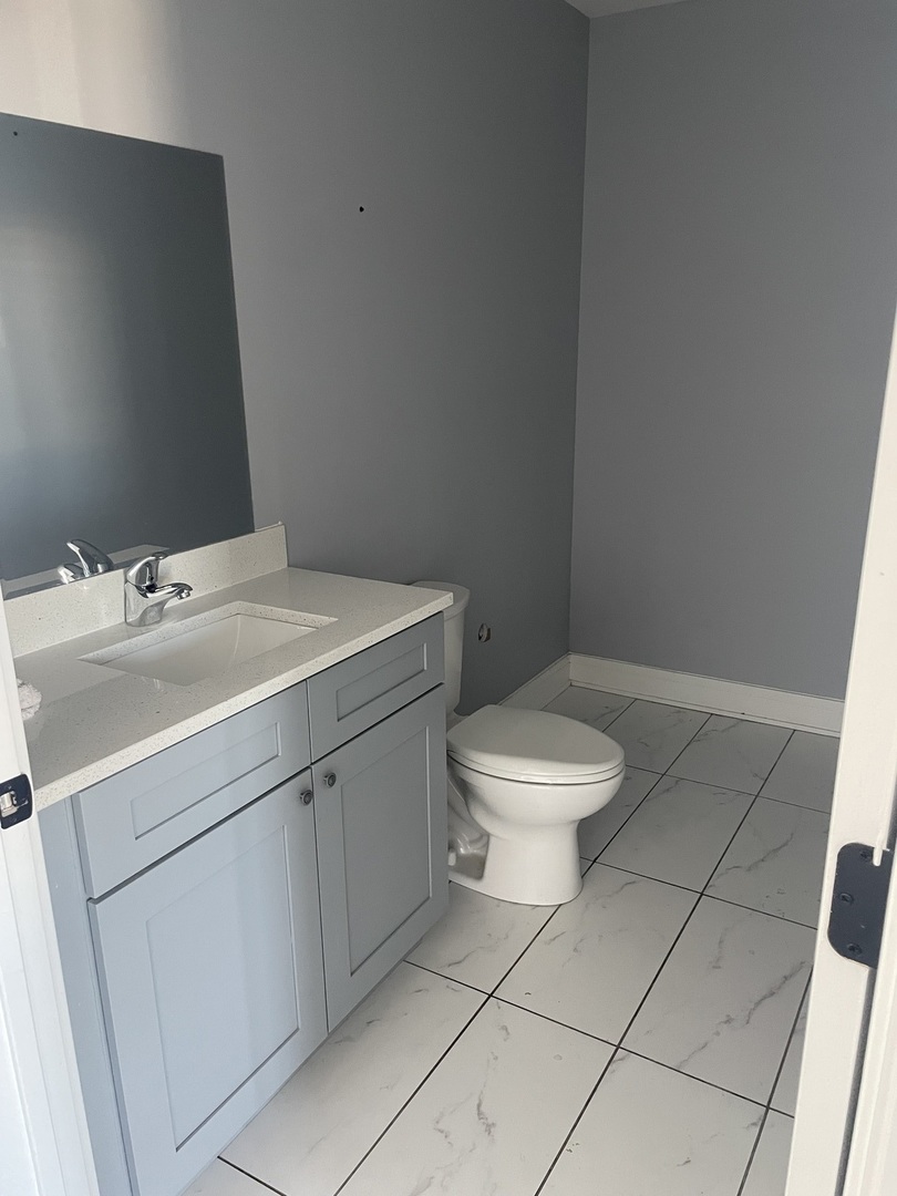 10301 South Kedzie Avenue, Unit 2 Chicago, IL 60655 - Photo 4 of 14 a bathroom with a toilet sink and mirror