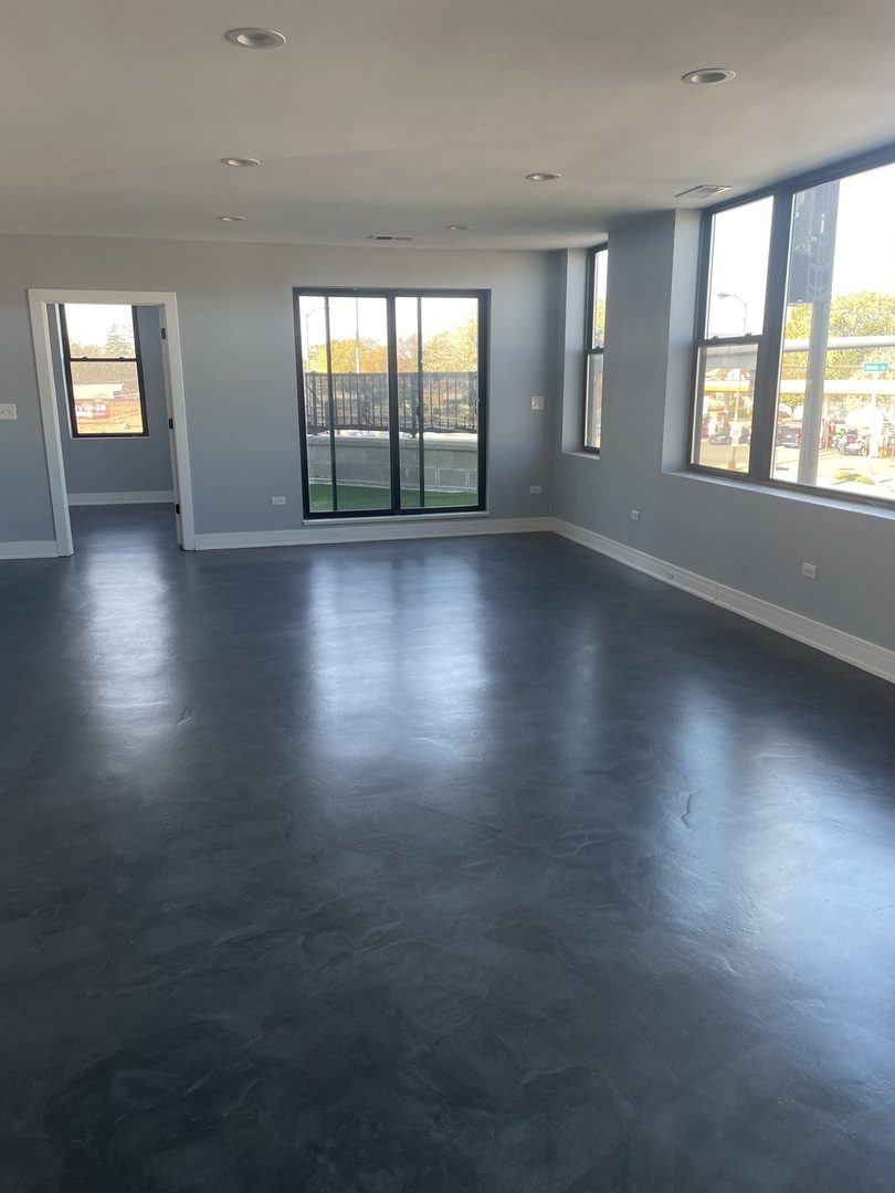 10301 South Kedzie Avenue, Unit 2 Chicago, IL 60655 - Photo 9 of 14 an empty room with wooden floor and windows