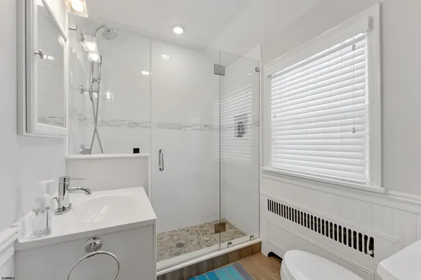 a bathroom with a sink a toilet and shower