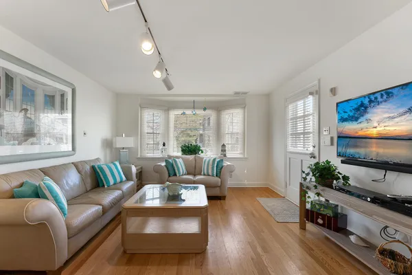 a living room with furniture flat screen tv and wooden floor