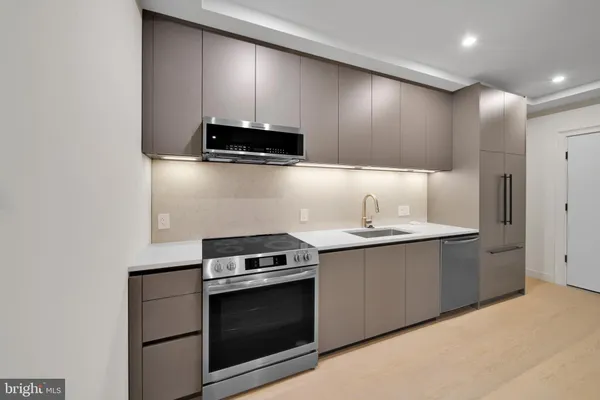 a kitchen with stainless steel appliances a sink stove and microwave