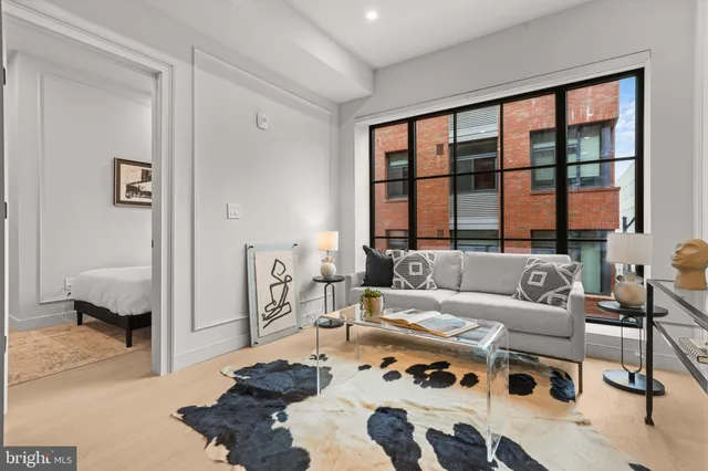 a living room with furniture a large window and a table