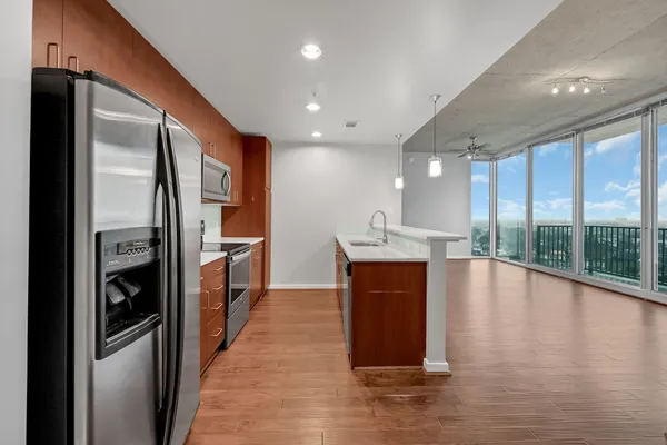 a open kitchen with stainless steel appliances granite countertop a refrigerator and a sink
