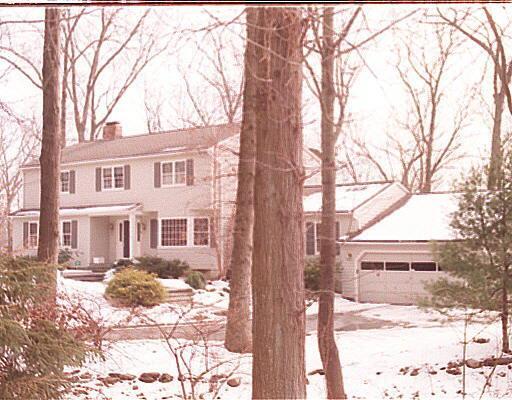 a front view of a house with a yard covered in snow