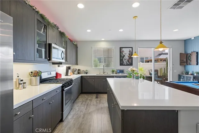 a kitchen with counter top space sink stove and wooden floor