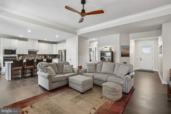 a view of a kitchen with kitchen island a sink appliances wooden floor and a counter top space