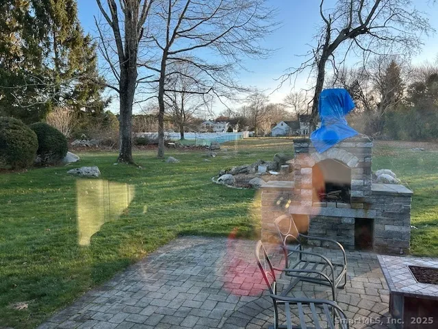 a view of lake with a table and chairs and a large tree