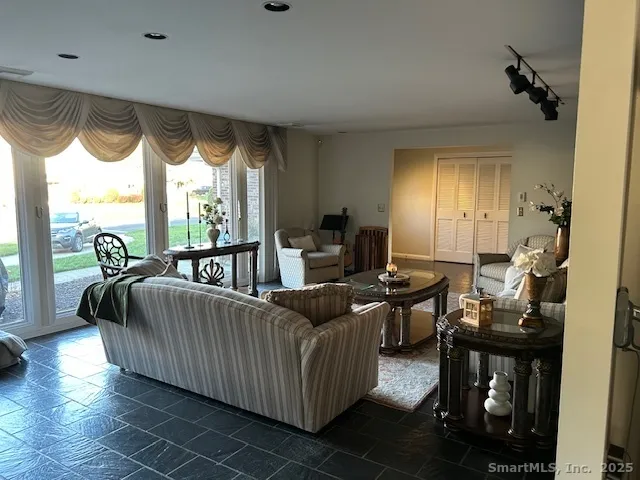 a living room with furniture and a floor to ceiling window
