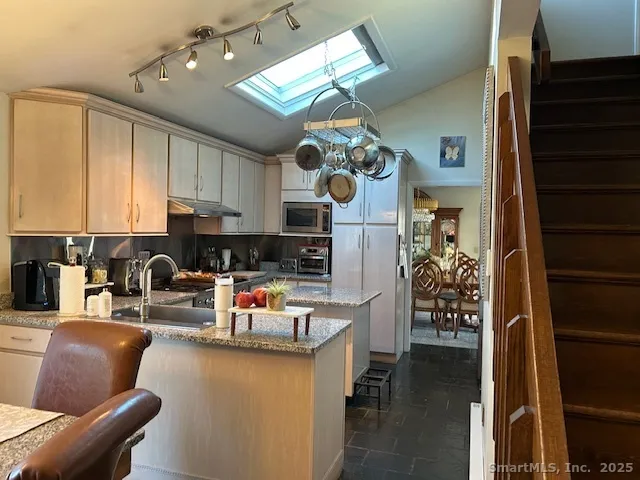 a kitchen with stainless steel appliances granite countertop a refrigerator and a stove top oven