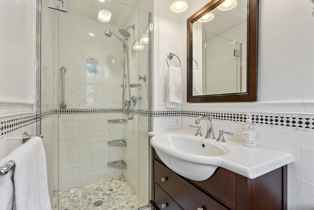 42 Bradyll Road Weston, MA 02493 - Photo 18 of 31 a bathroom with a sink a mirror and shower