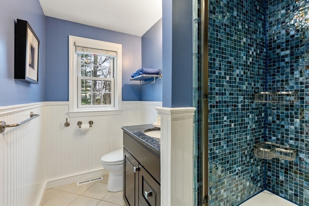 42 Bradyll Road Weston, MA 02493 - Photo 22 of 31 a bathroom with a granite countertop toilet a sink a mirror and shower