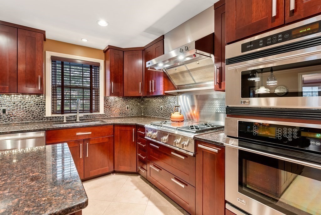 42 Bradyll Road Weston, MA 02493 - Photo 7 of 31 a kitchen with stainless steel appliances granite countertop a stove and a microwave