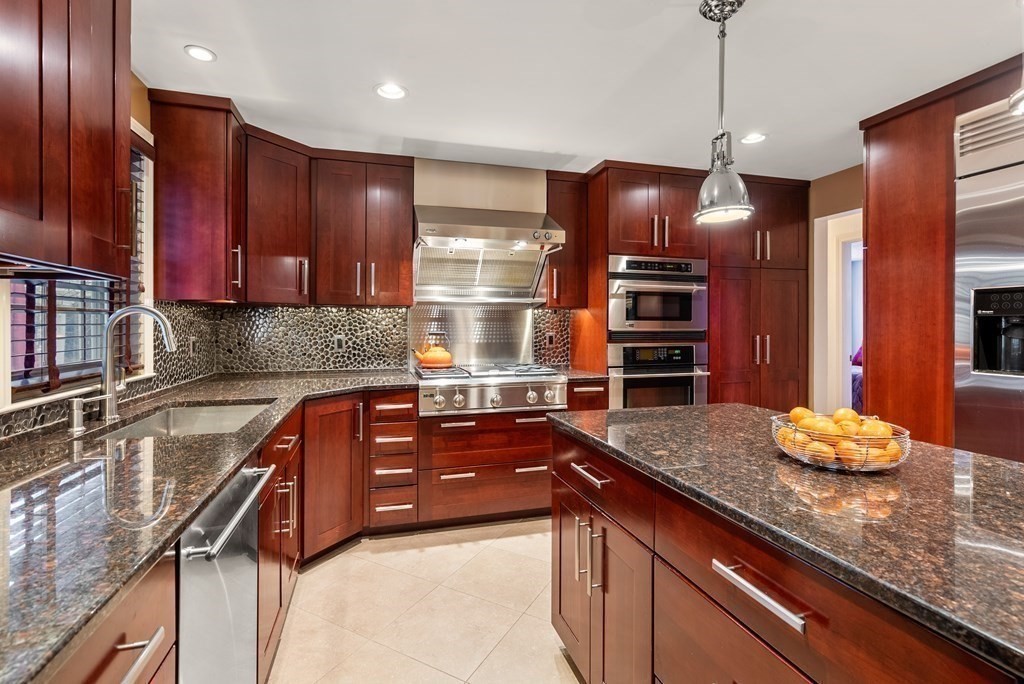 42 Bradyll Road Weston, MA 02493 - Photo 8 of 31 a kitchen with stainless steel appliances granite countertop a sink and a stove