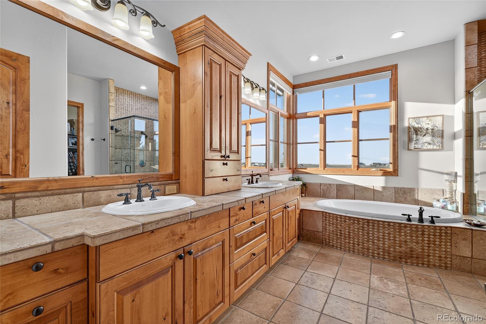 5001 Raintree Circle Parker, CO 80134 - Photo 11 of 50 a spacious bathroom with a double vanity sink large mirror and a bathtub