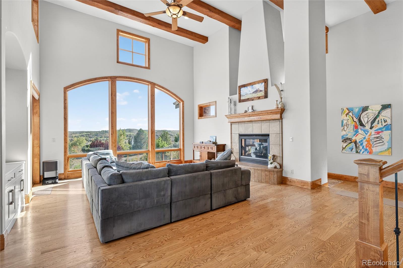 5001 Raintree Circle Parker, CO 80134 - Photo 15 of 50 a living room with furniture a fireplace and a floor to ceiling window
