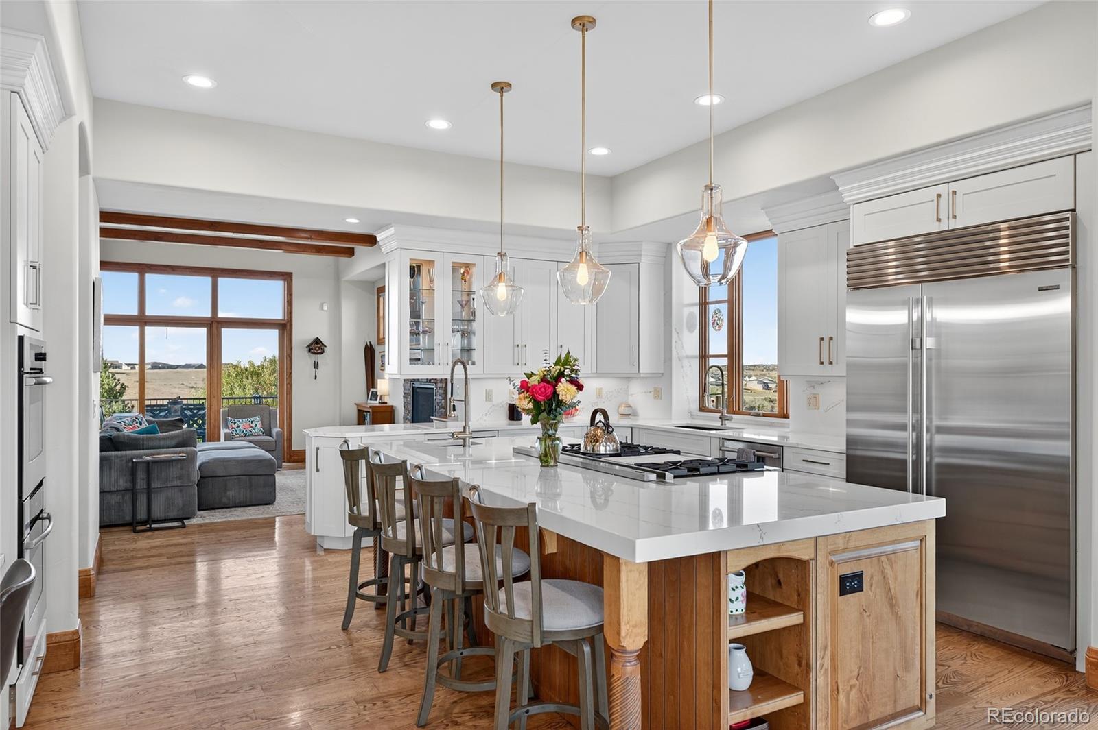 5001 Raintree Circle Parker, CO 80134 - Photo 19 of 50 an open kitchen with granite countertop a stove a sink a dining table and chairs
