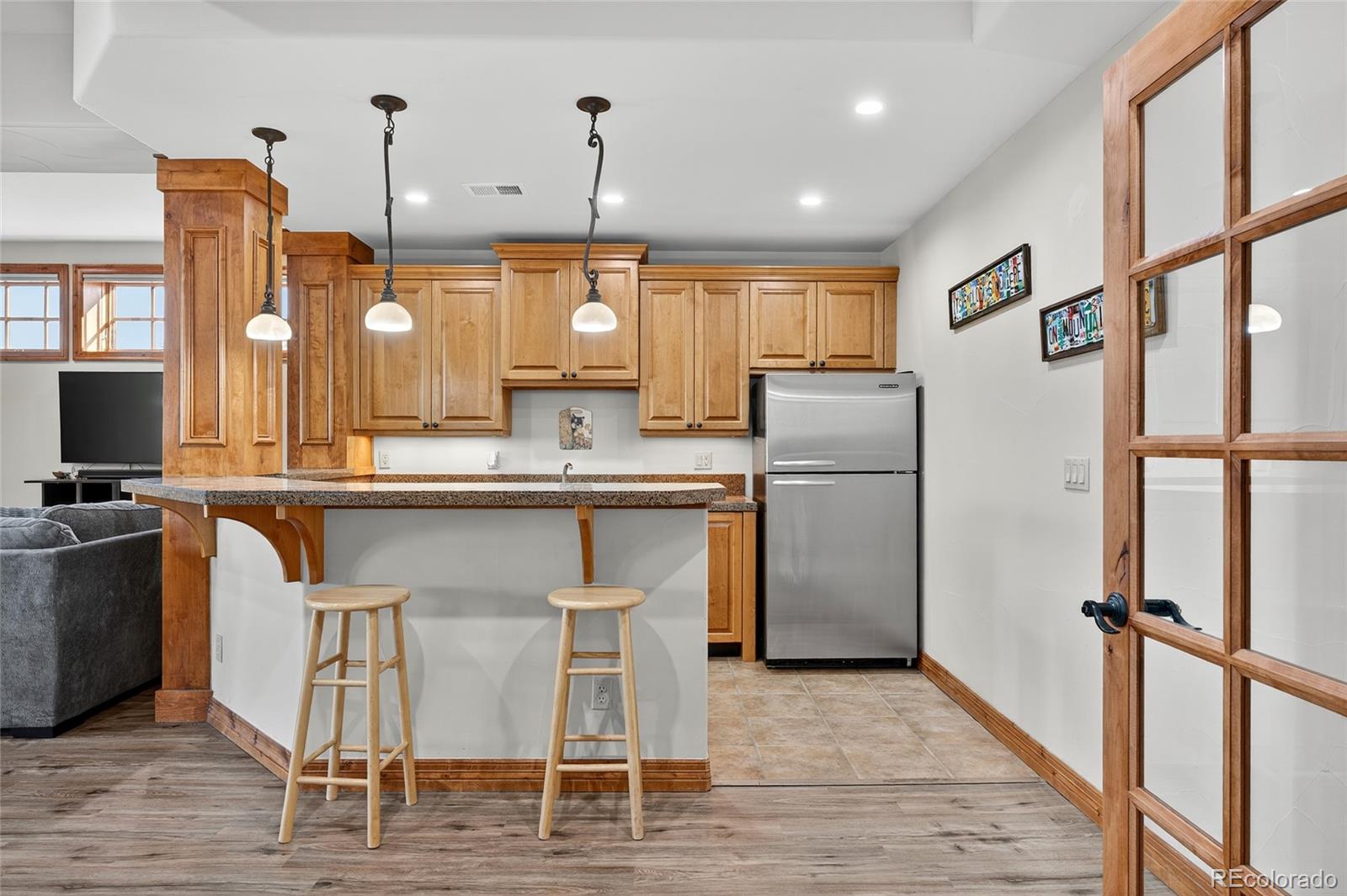 5001 Raintree Circle Parker, CO 80134 - Photo 41 of 50 a kitchen with kitchen island granite countertop a refrigerator a stove a sink cabinets and wooden floor