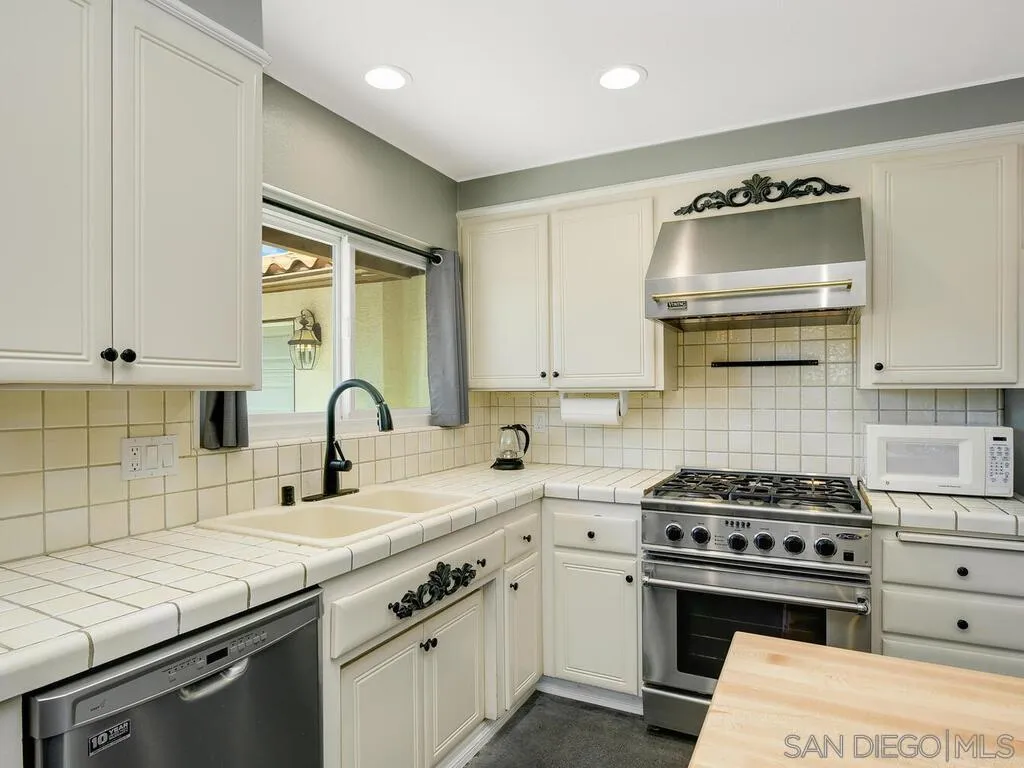 1506 Renwick Lane Vista, CA 92084 - Photo 4 of 28 a kitchen with granite countertop a sink cabinets and stainless steel appliances
