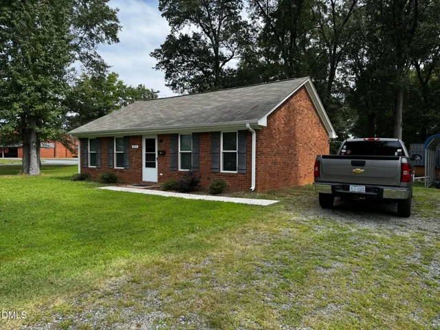 a view of a house with a yard and sitting area