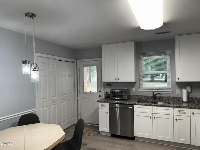 a kitchen with a white cabinets and window