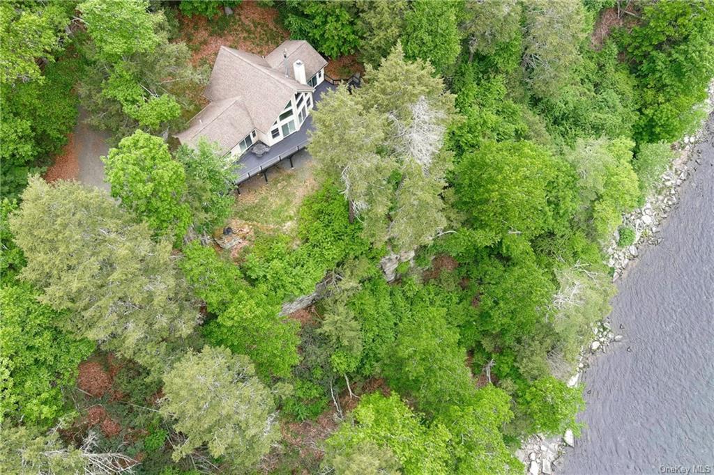 an aerial view of a house with a yard and trees all around