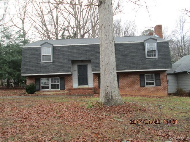 a front view of a house with yard and trees