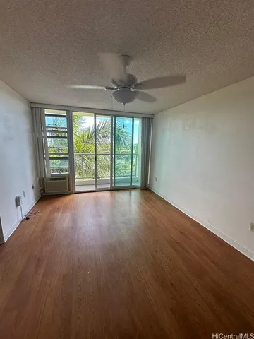 an empty room with wooden floor and balcony