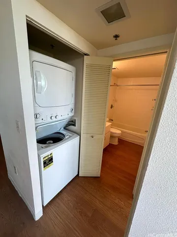 a utility room with wooden floor washer and dryer