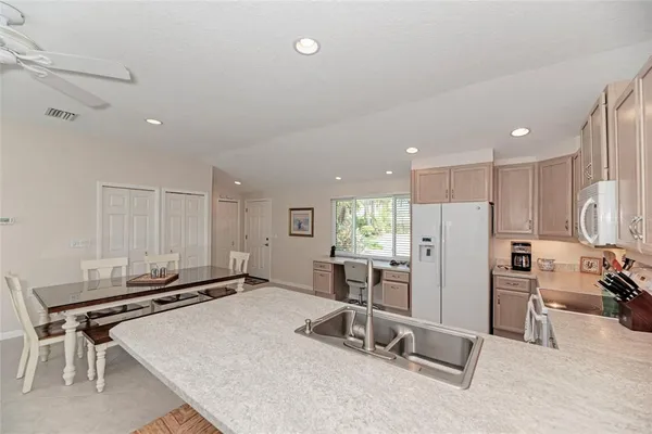 a room with a table chairs and refrigerator