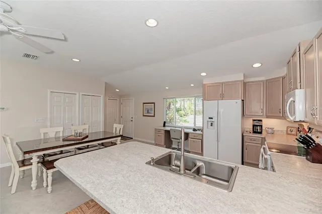 a room with a table chairs and refrigerator